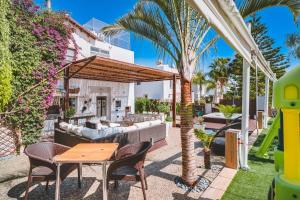een patio met een tafel en stoelen en een huis bij SunnyVillas: 4BR Villa☆Private Pool + Jacuzzi - Villa Amelie in Protaras