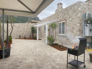 una casa in pietra con patio e camino di Villa Milisa a Terrasini