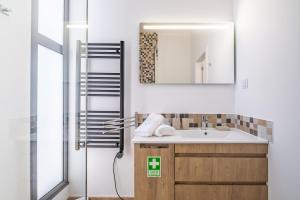 a bathroom with a sink and a mirror at Villa Plumeria in Arco da Calheta