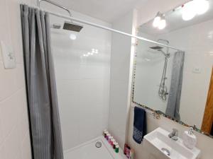uma casa de banho branca com um chuveiro e um lavatório. em Full equipped and comfortable apartment with WiFi em Valência