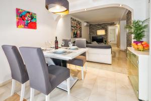 a dining room and living room with a white table and chairs at Spacious 2BD, fully equipped for a relaxing holiday in Split