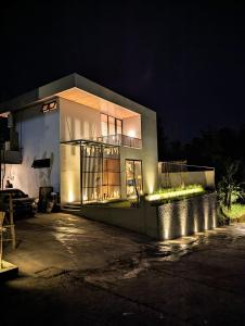 un bâtiment avec des lumières sur son côté la nuit dans l'établissement Cottonwood Exclusive Villa Sagarmatha @Puncak, à Bogor