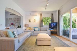 ein Wohnzimmer mit einem Sofa und einem TV in der Unterkunft Embat in Colònia de Sant Pere