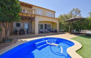 a swimming pool in front of a house at Embat in Colonia de Sant Pere