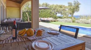 - une table avec une assiette de fruits et une bouteille de vin dans l'établissement Embat, à Colònia de Sant Pere