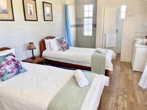 a room with two beds and a sink in it at Bellevue Berg Cottage in Bergville