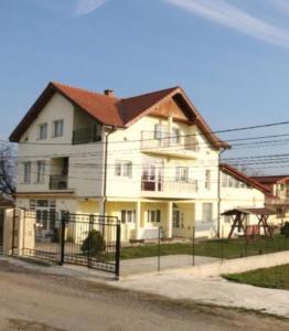 a large white house with a fence in front of it at VLAD&ELISA in Bacău