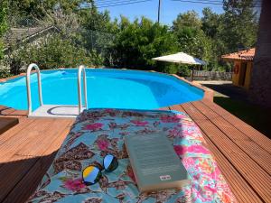 ギマランイスにあるBERGUI Guesthouse - Guimarãesのスイミングプール横の毛布に座る本