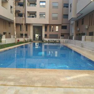 a large blue swimming pool in front of a building at Appart Kech Menera in Marrakech