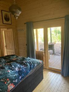 een slaapkamer met een bed en een glazen schuifdeur bij Berghut in Doorn