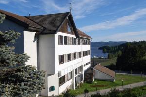 a white building with a view of a lake at Norsjø Hotell in Akkerhaugen