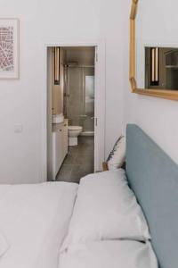 a bedroom with a bed and a mirror and a bathroom at Stylish apartment in the centre of Madrid-Malasaña in Madrid