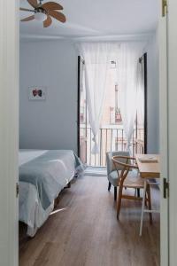 a bedroom with a bed and a table and a window at Stylish apartment in the centre of Madrid-Malasaña in Madrid