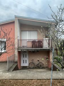 uma bicicleta estacionada ao lado de uma casa com varanda em Apartment Lazar & Marco em Podgorica