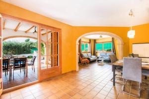 sala de estar con paredes de color naranja y comedor en Villa Oceanic - PlusHolidays en Calpe