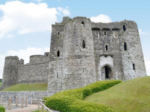 a castle on top of a grassy hill at Y Beudy in Llannon