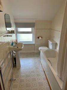 a bathroom with a tub and a sink and a toilet at The Lookout in Ilfracombe