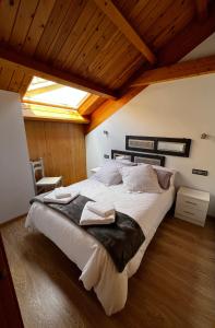 een slaapkamer met een groot bed in een kamer met houten plafonds bij Duplex en Casco Histórico in León
