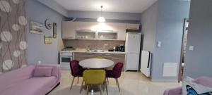 ein Wohnzimmer mit einem Tisch und Stühlen sowie eine Küche in der Unterkunft Summertimes in Alexandroupoli