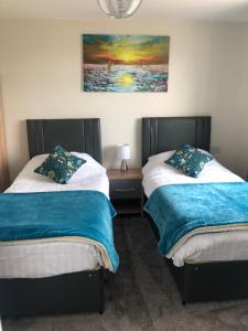 two beds sitting next to each other in a bedroom at High Ways House in Woolacombe