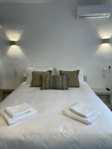 a white bed with two towels on top of it at Dryopis Studio in Dhriopís