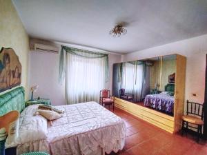 ein Schlafzimmer mit einem Bett und einem Spiegel in der Unterkunft Villa Elba in Praia a Mare