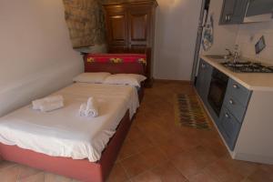 two beds in a small room with a kitchen at Residenza Audè in Monastero Bormida