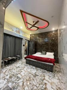 een slaapkamer met een bed en een plafondventilator bij Kashi Dham Home Stay in Varanasi