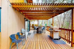 a patio with chairs and a grill on a deck at Creekside Cabin in Groveland