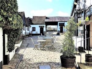 um pátio com uma mesa e cadeiras num edifício em The Old Barn Little Wing em Amersham