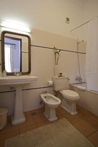 y baño con aseo, lavabo y espejo. en Betica Hotel Rural, en Pias
