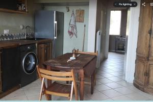 a kitchen with a wooden table and a refrigerator at Lovely 1-Bed Apartment literally on the beach in Cerbère