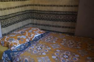 a bed with an orange and blue comforter on it at Lovely 1-Bed Apartment literally on the beach in Cerbère