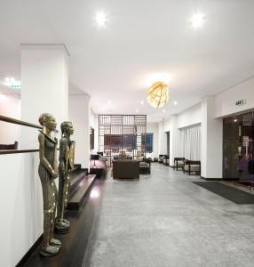 un hall avec deux statues sur le mur dans l'établissement Hotel Tivoli Beira, à Beira