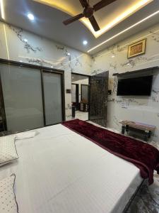 a large bed in a room with a flat screen tv at Kashi Dham Home Stay in Varanasi