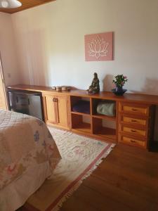 a bedroom with a dresser and a desk with a plant on it at Reino Solar in Cunha