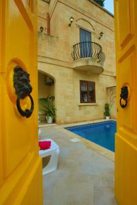 una puerta a una casa con piscina en Farmhouse Renee, en Qala