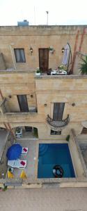 an overhead view of a building with a swimming pool at Farmhouse Renee in Qala