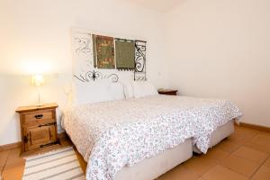 a bedroom with a bed and a table and a lamp at Betica Hotel Rural in Pias