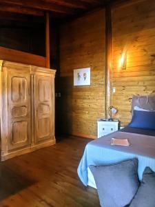 a bedroom with a bed and a wooden wall at Chalés Paris in Paraty