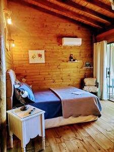 um quarto com uma cama num quarto de madeira em Chalés Paris em Paraty