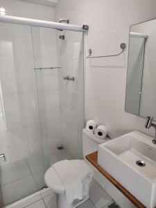een badkamer met een douche, een toilet en een wastafel bij Jequitiba Hotel Frente ao Mar in Guarujá