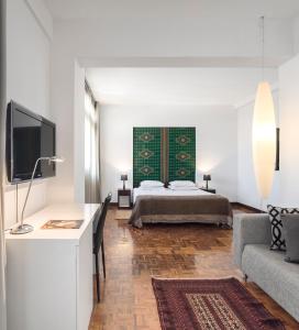 a living room with a bed and a couch at Hotel Tivoli Beira in Beira