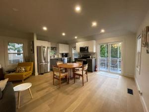 cocina y sala de estar con mesa y sillas en Tranquil Cottage Retreat in Prince Edward County, en Demorestville