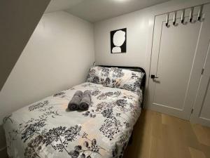 a bedroom with a bed with a black and white comforter at Tranquil Cottage Retreat in Prince Edward County in Demorestville