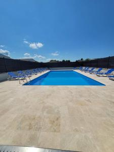 una piscina con tumbonas y una piscina azul en LA CASA, en Biville-sur-Mer