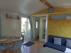 a living room with a table and a blue couch at LA CASA in Biville-sur-Mer