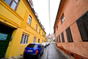 a blue car parked on a street next to buildings at FLH - Zen Apartment in Sibiu