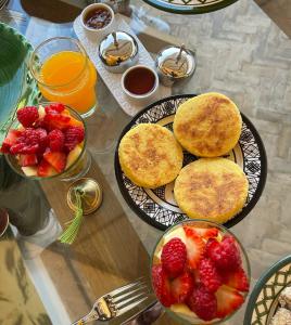 a table with pancakes and strawberries and some juice at RIAD EN EXCLUSIVITE SUITE MEDINA BY DO in Marrakesh