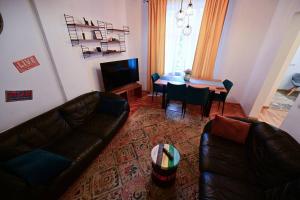a living room with a leather couch and a table at FLH - Zen Apartment in Sibiu